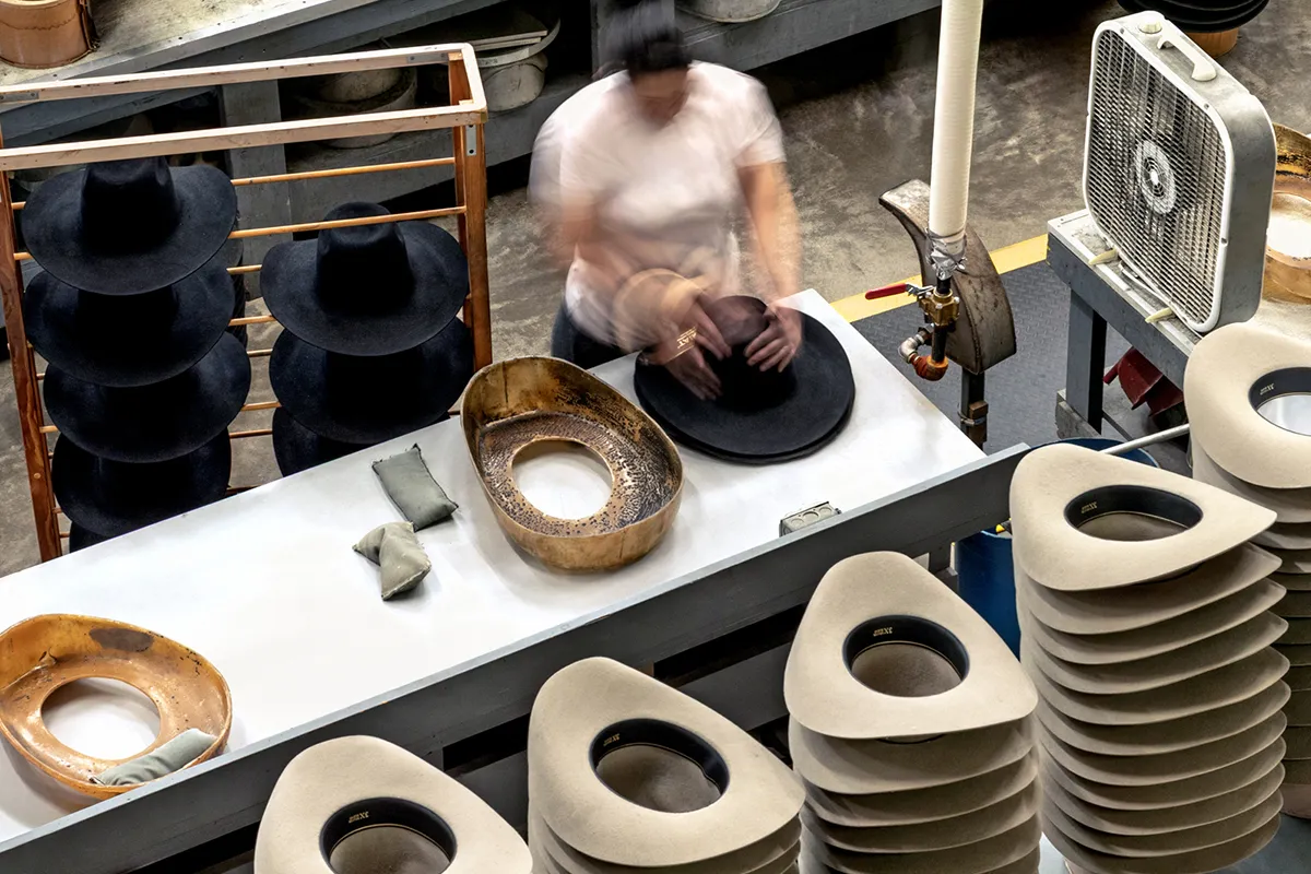 Hat maker in Texas hand shaping felt cowboy hat with steam
