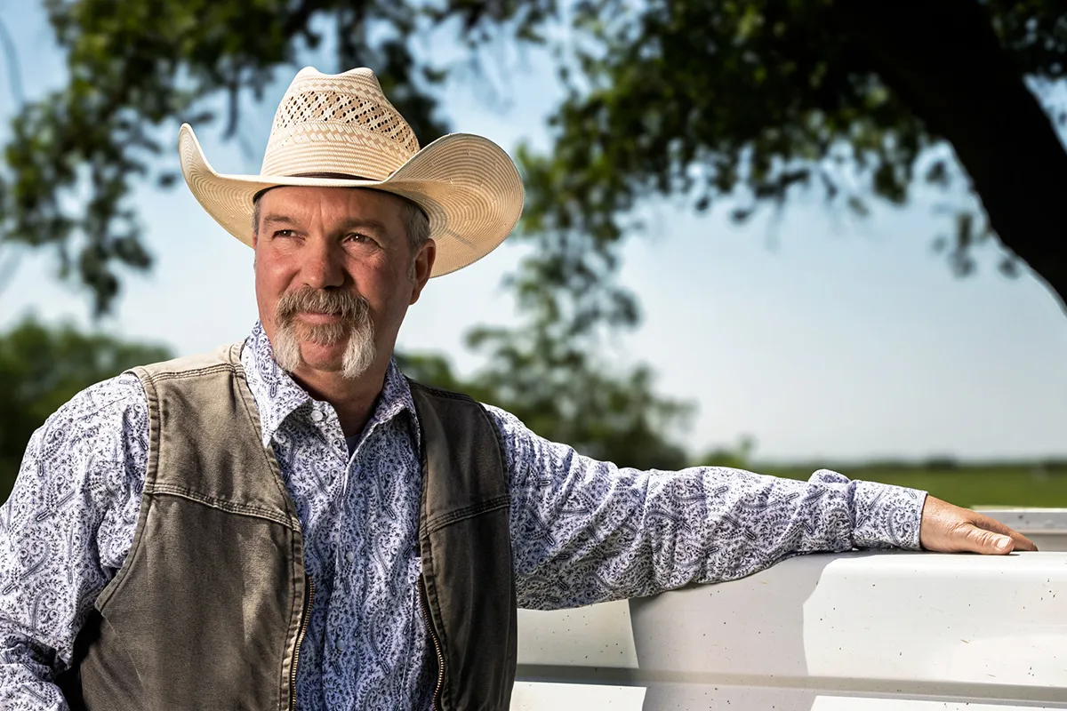 Texan leaning on truck wearing Master Hatters cowboy hat